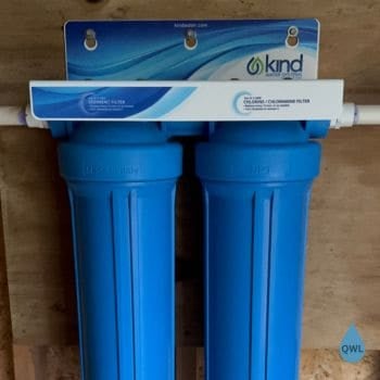 Kind 1000 whole house water filter installed on wall with dual blue housings