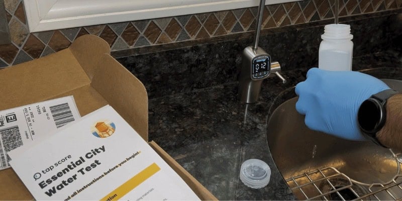 Collecting a water sample using a Waterdrop RO faucet for lab testing with an Essential City Water Test kit.