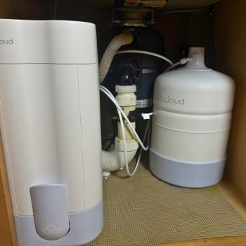 Cloud RO filter unit and pressurized storage tank installed under kitchen sink showing real-world under-sink footprint