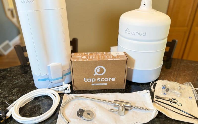 Cloud RO system unboxed with storage tank, faucet, tubing, installation hardware, and Tap Score water test kit